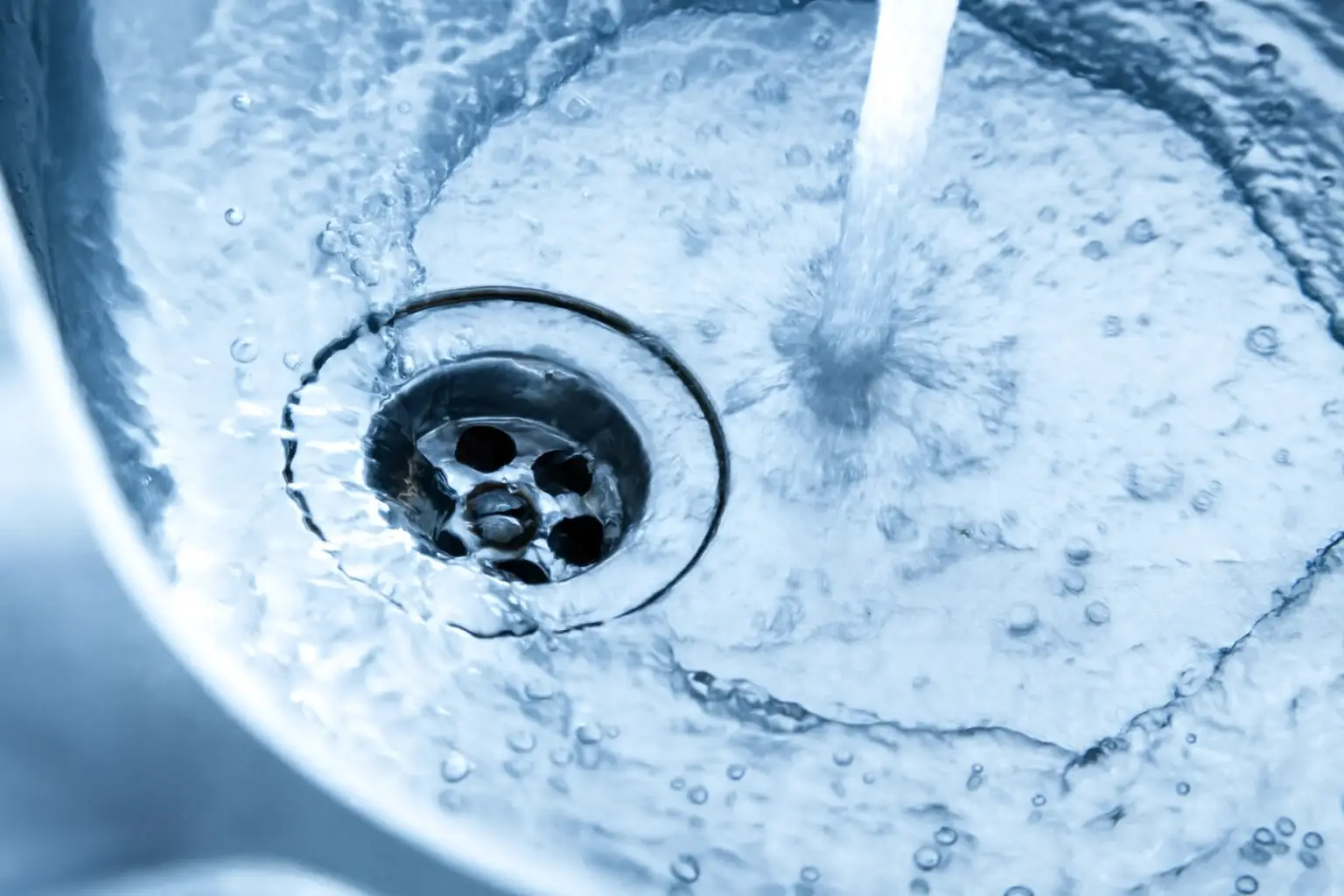 Eau tourbillonnante dans l'évier métal